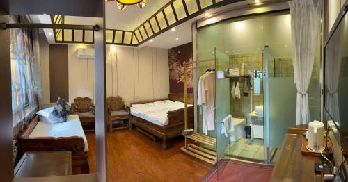 a room with a bed and a glass shower at Pingyao HongJingYuanGuesthouse in Pingyao