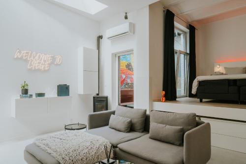 a living room with a couch and a bed at Luxury loft with private parking in Liège