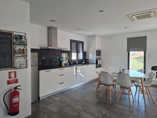 a kitchen with white cabinets and a table and chairs at The Douro Nest in Valença do Douro