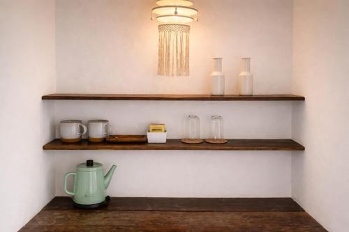 a room with wooden shelves with glass vases and a light at Riva Boutique Resort Koh Chang in Ko Chang