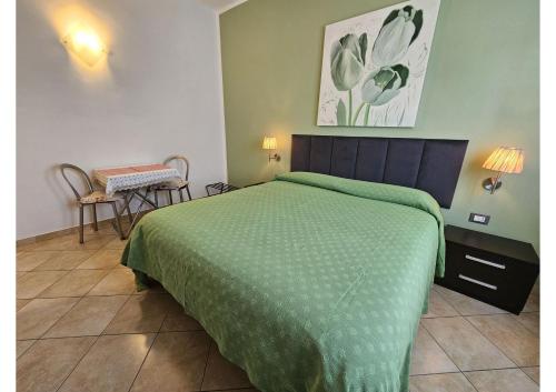 a bedroom with a bed with a green comforter at Guest house Il Giardino in Città in La Spezia
