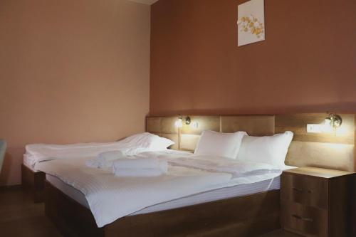 a bedroom with a large bed with white sheets at Hotel Horizont Telavi in Telavi