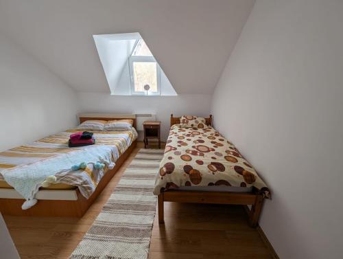 a bedroom with two beds and a window at Peste Vale in Poşaga de Sus