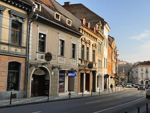 a city street with buildings on the side of the road at Hotel Bella Muzica in Braşov