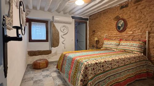 a bedroom with a bed and a stone wall at La Maison de Magdala in Ronda