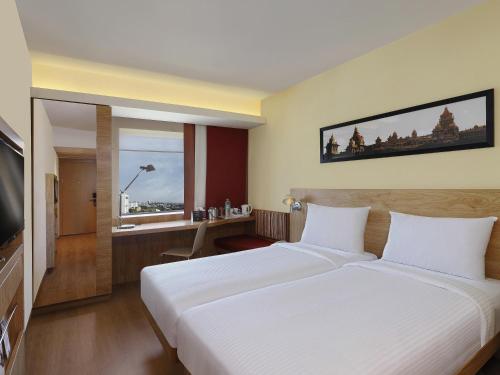 a hotel room with a bed and a television at Ibis Chennai OMR - An Accor Brand in Chennai