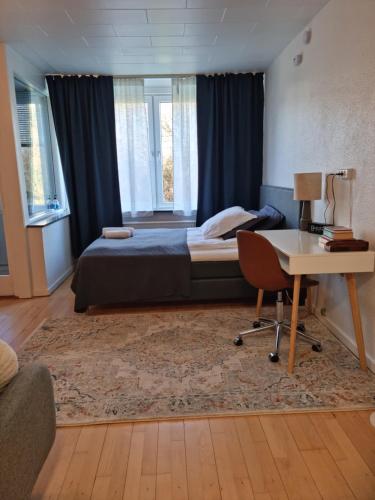 a bedroom with a bed and a desk and a desk at Bayer Apartments Copenhagen in Rødovre