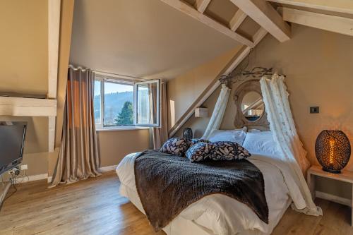 a bedroom with a bed with a large window at Le B Cottage & SPA Privé in Riquewihr
