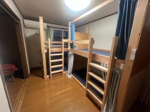 a dorm room with two bunk beds and a window at 旭川ロキ in Asahikawa
