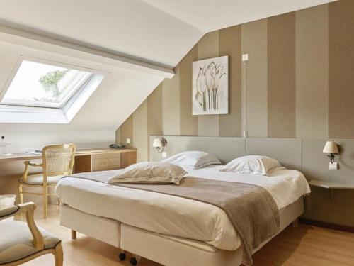a bedroom with a large bed and a chair at Hotel Le Beau Séjour in Nassogne