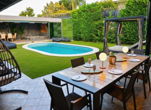 a patio with a table and chairs and a swimming pool at Casa Del G in Metókhi
