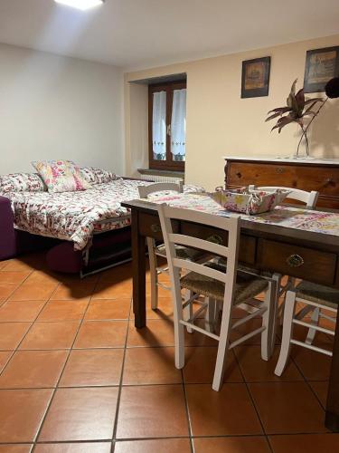 a living room with a table and a bed at Casa San Rocco in Busalla