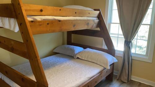 two bunk beds in a room with a window at Sail Away in Cape May Point