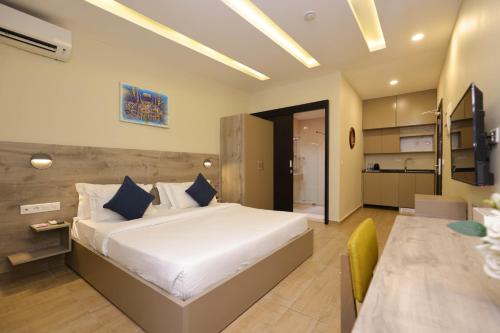 a bedroom with a large bed and a kitchen at Silver Moon Hotel in Abidjan