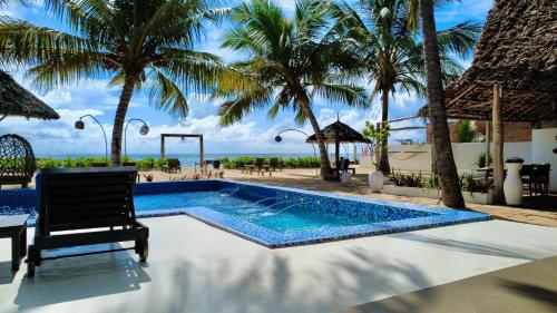 a swimming pool with a chair and palm trees at TWIGA APARTHOTEL by Sofia Collection in Pwani Mchangani