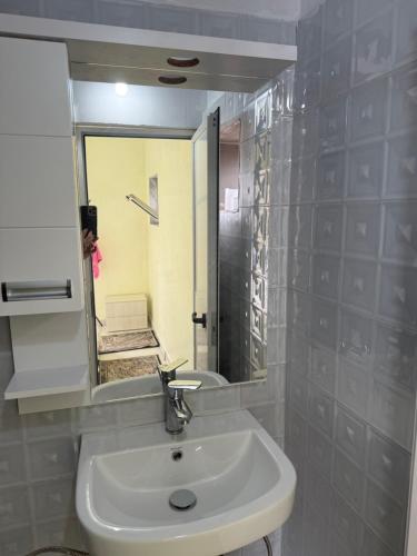a bathroom with a sink and a mirror at Antoni Guest House & Café in Lekaj