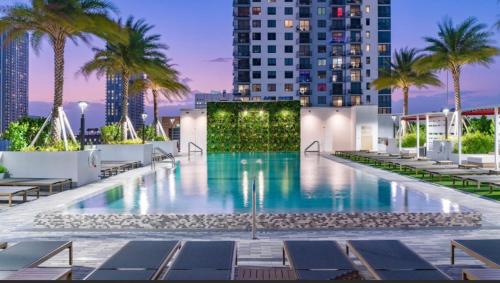 a swimming pool on the roof of a building with palm trees at Prime Miami location - Modern Skyline Stay in Miami