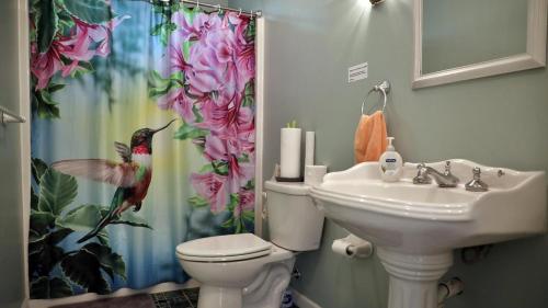 a bathroom with a toilet and a shower curtain with a bird on it at Failte in West Cape May