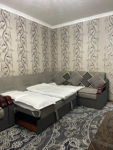 a bedroom with two beds and a wall with wallpaper at MOK Apartment in Samarkand