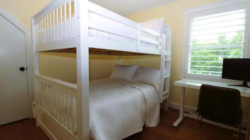 a bedroom with a white bunk bed and a desk at Beach Croft in West Cape May