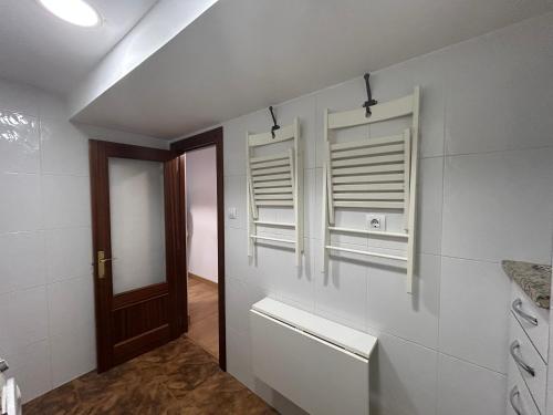 a bathroom with white walls and windows and a door at La Costa Suite in Gijón