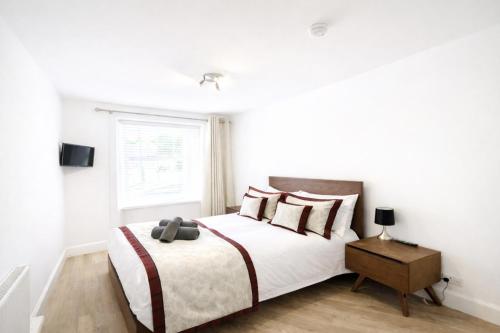 a white bedroom with a bed and a window at Taigh Oisean 4 Birnam Place Pitlochry in Pitlochry
