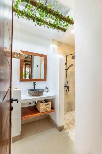 a bathroom with a sink and a mirror at Roh Villas Kuta Lombok in Kuta Lombok
