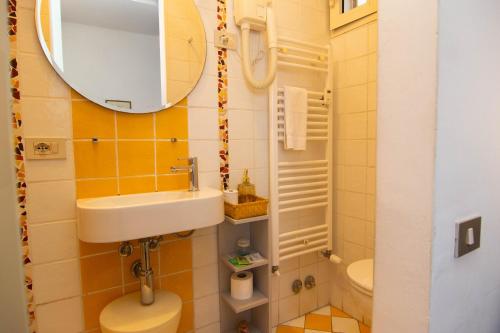 a bathroom with a sink and a toilet and a mirror at B&B Dei Cavalieri in Pisa