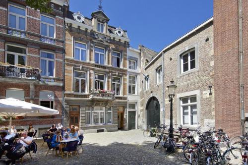 a group of people sitting at tables in front of buildings at The Art Residence Maastricht in Maastricht