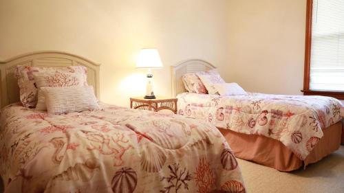 a bedroom with two beds and a lamp at Relief Cape May Point in Cape May Point