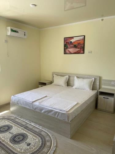 a bedroom with a bed and a rug at Mahdiy Hotel in Khiva
