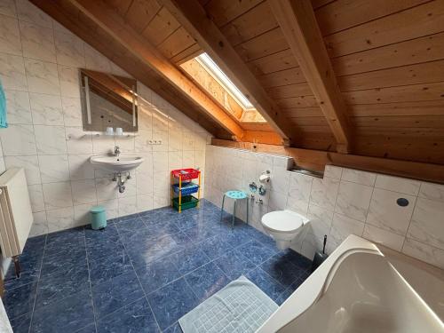a bathroom with a tub and a sink and a toilet at Appartementhaus Marion in Bad Bayersoien