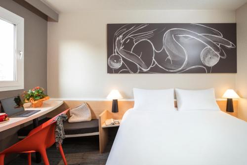 a hotel room with a bed and a desk and a chair at ibis Dieppe Le Val Druel in Dieppe