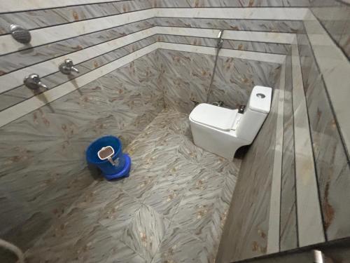 a bathroom with a white toilet and a blue object at Hotel Laxmi Palace in Khātu