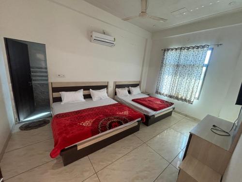 a bedroom with two beds and a window at Hotel Laxmi Palace in Khātu