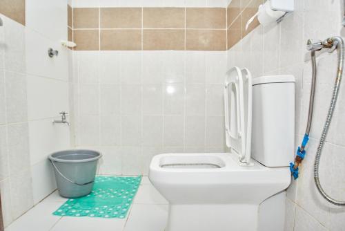 a bathroom with a toilet and a trash can at Diani Dream stays in Diani Beach