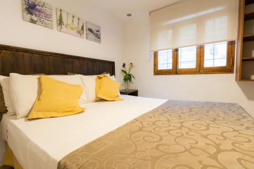 a bedroom with a large bed with yellow pillows at Cabañas del Cerro in Valle Grande