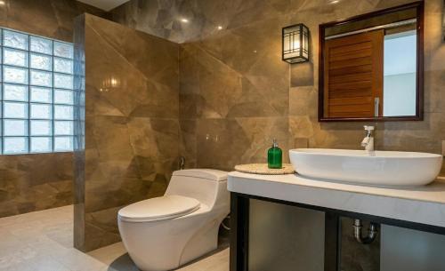 a bathroom with a toilet and a sink at Juminten Villa in Ubud
