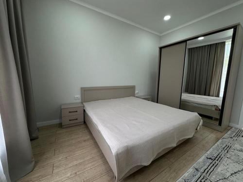 a bedroom with a white bed and a window at Royal Beach Cottage Issyk Kul in Chok-Tal