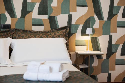 a hotel room with a bed with towels on it at Le Rose Suites - Misano World Circuit & Beach in Misano Adriatico
