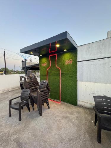 a group of chairs sitting in front of a green wall at hotel apni haveli in Mandsaur