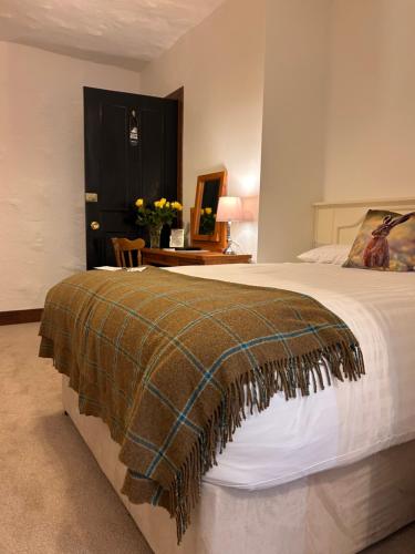 a bedroom with a bed with a blanket on it at Ryan's River Lodge B&B in Cong