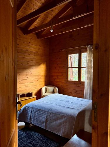 a bedroom with a bed in a wooden room at Η σπηλιά του Θουκυδίδη in Spilia