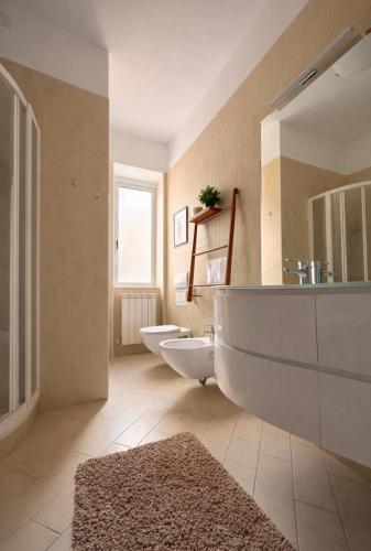 a bathroom with two sinks and a tub and two toilets at Casa aMare in Chioggia