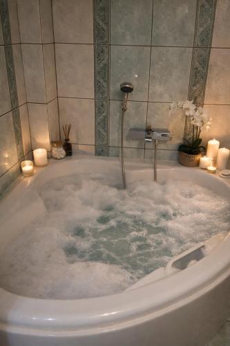 a bath tub filled with water with candles in it at A&S Luxury Apartment in Kavála