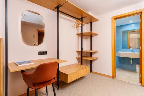 a bathroom with a desk and a mirror at Cascais Hotel in Cascais