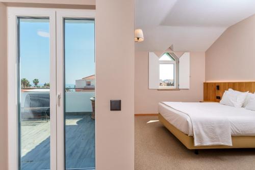 a bedroom with a bed and a balcony at Cascais Hotel in Cascais