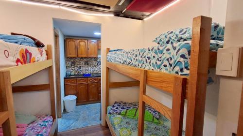 a room with two bunk beds and a kitchen at Hostal SAVEVA in Medellín