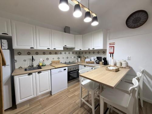 a kitchen with white cabinets and a wooden table at Casa do Serro de Lá in Santa Clara-a-Nova