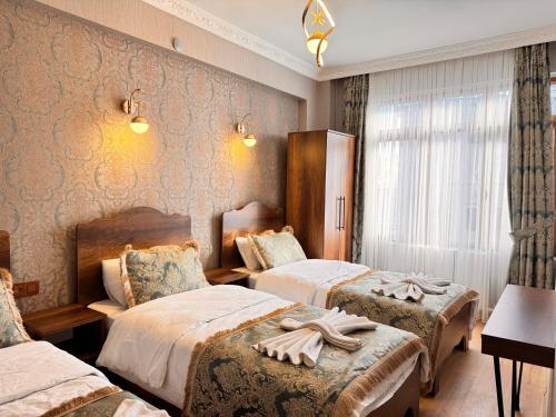 a hotel room with three beds with towels on them at Nasip House in Istanbul